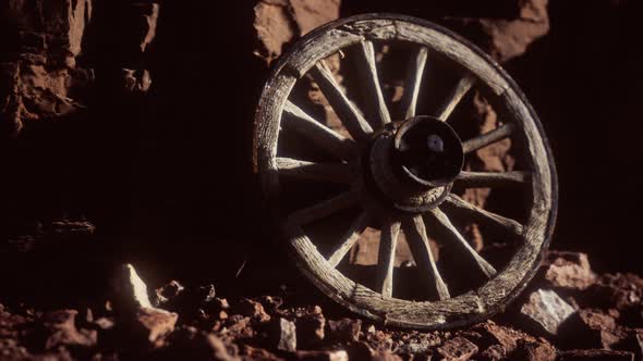 Old Wooden Cart Wheel on Stone Rocks