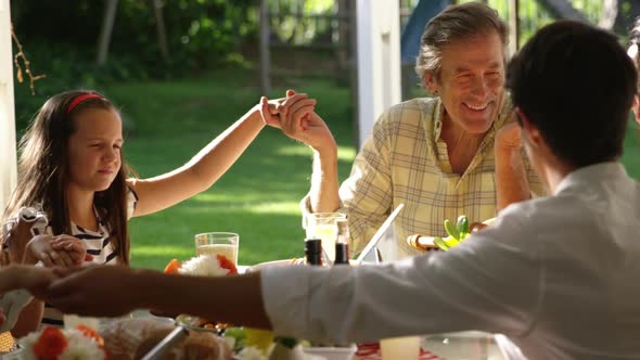 Family eating outside together in summer