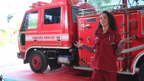 Emergency doctor stand in front of firetruck and action look like report or explain in front truck