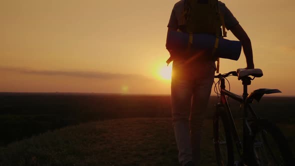 A Cyclist with a Backpack Behind Her Back Enters the Frame