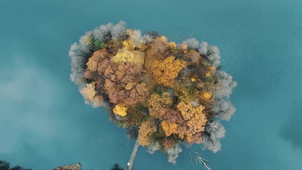 Camera Zooms Out Flying Around Island in Turquoise Water