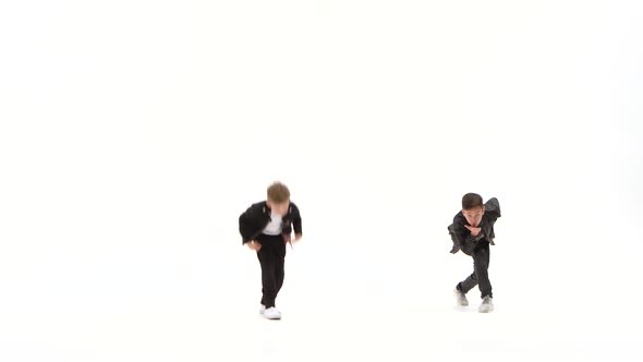 Little Boys Are Dancing a Modern Dance on the White Background in Black Leather Jackets and Jeans