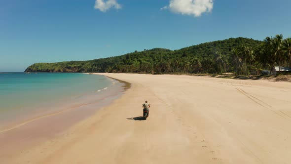 Man Driving a Motorcycle on Beach