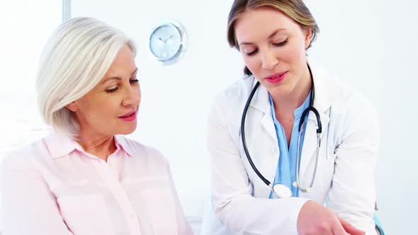 Female doctor and colleague discussing over digital tablet