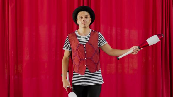 Male circus artist juggling with clubs