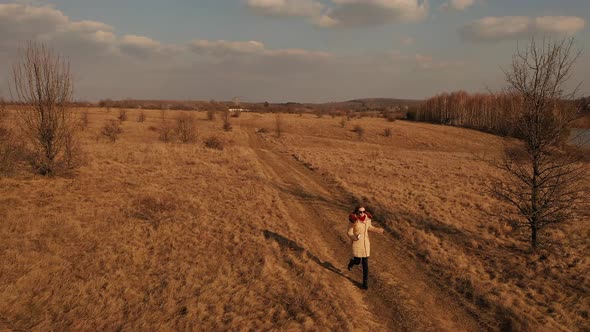 Young Woman in Sunglasses Warm Long Jacket Runs Autumn Dry Meadow Sunny Weather