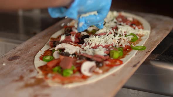 Ready-to-bake pizza, pouring cheddar.