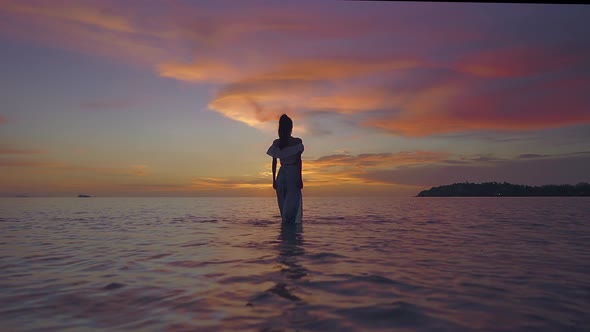 Woman Silhouette Walking Alone in the Sea at Beautiful Sunset Thailand
