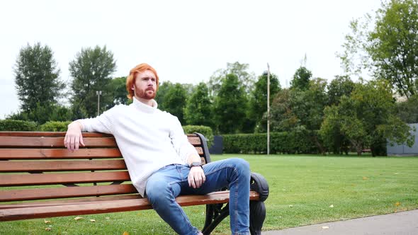 Waiting Man Sitting in Park on Bench, Red Hairs and Beard