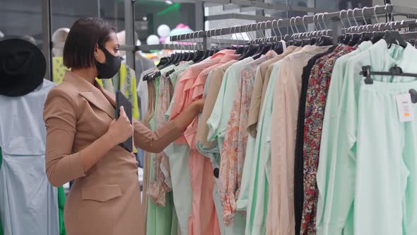 Young African Female in a Clothing Store Sales Representative Takes Inventory in a Clothing Store