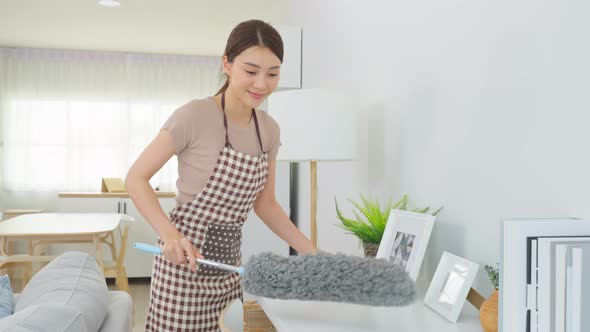 Asian young cleaning service woman worker cleaning in living room at home for housekeeping housework