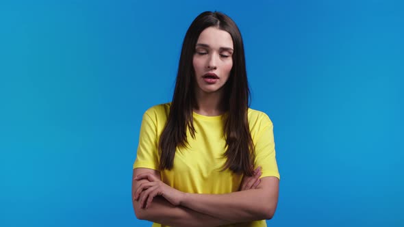 Irritated Woman in Yellow Sighs Rolling Eyes on Blue Background