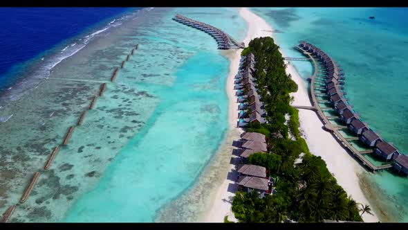 Aerial drone shot panorama of marine seashore beach time by turquoise water with clean sandy backgro