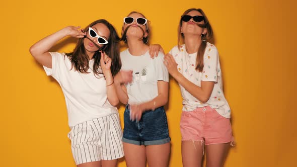 Three young beautiful smiling hipster girls in summer clothes