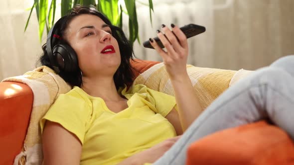 Happy smiling woman headphones in holding mobile phone speaking talking with friends