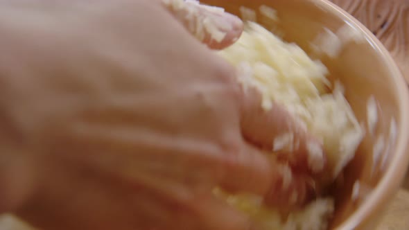 SAUERKRAUT - Hands squeezing cabbage and turning bowl, close up tracking right