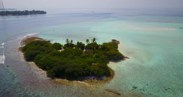 Tropical above island view of a white sand paradise beach and aqua blue water background in vibrant 