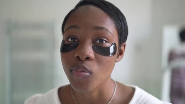 Headshot Portrait of Young Beautiful Woman with Eye Patches Smiling Looking at Camera