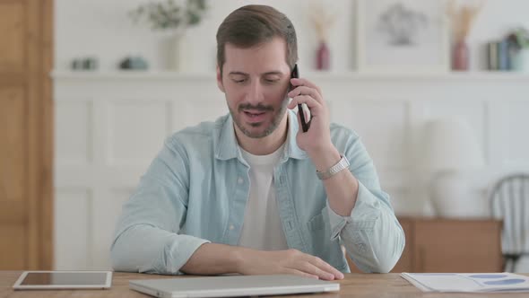 Young Man Talking on Phone in Office