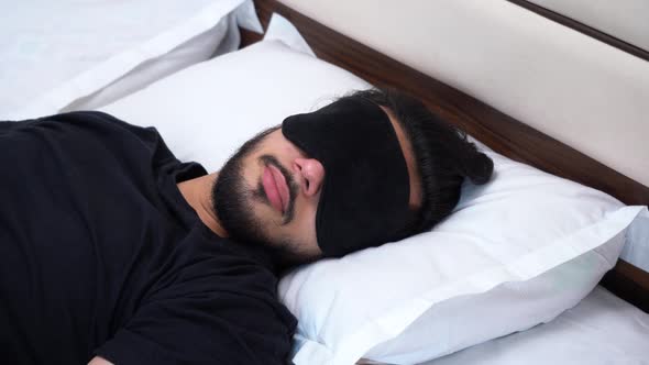 Indian man sleeping with an eye mask on