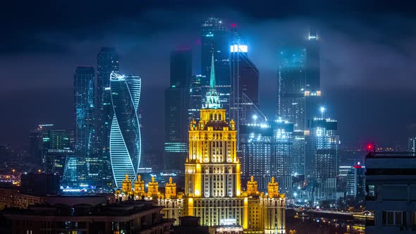 Time lapse of the clouding over tall building in the city at night. skyscrapers covered with the fas