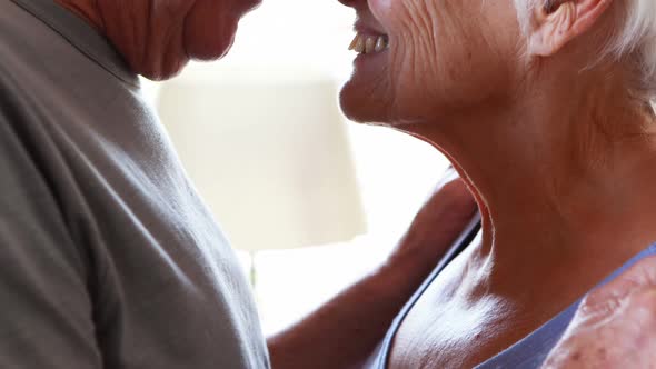 Happy senior couple romancing in bedroom