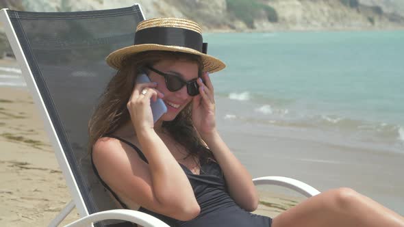 Beautiful Smiling Woman Lying on Deck Chair 