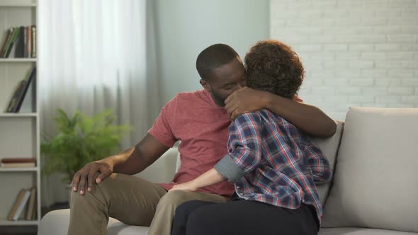 Happy Family Couple Sitting on Sofa Talking and Enjoying Pastime With Each Other