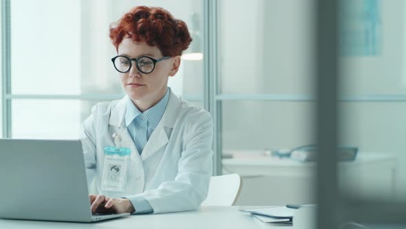 Portrait of Young Female Doctor at Workplace in Medical Office