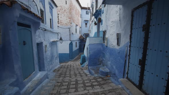 Walking Down Stairs in Narrow Street in Blue City of Chefchaouen