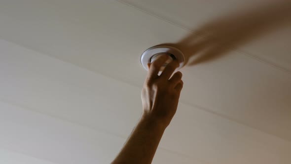 The Man Turns Off the Electricity and Unscrews the Light Bulb From the Ceiling