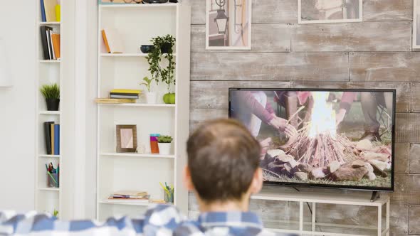 Back View of Man Sitting Alone on Couch and Watching Tv