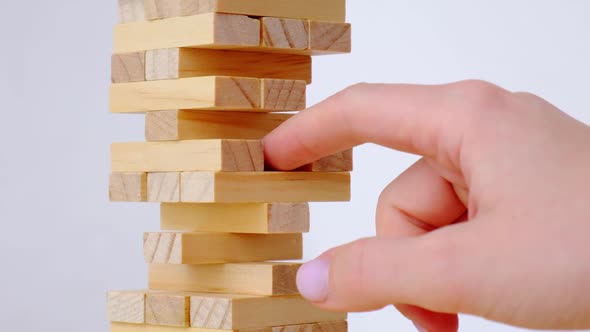 Female Hand Playing Wooden Block Removal Tower Game at Home