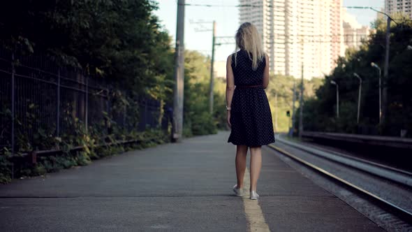 Woman In Dot Dress Walking On Railroad Station Platform. Girl Waiting Train On Public Transport.