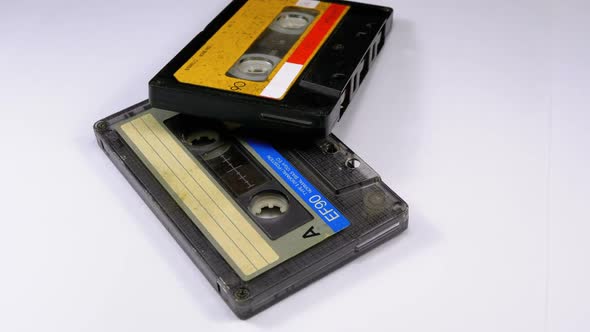 Two Audio Cassettes Rotate on White Background