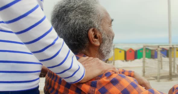 Mid section of active senior African American woman put her hand on disabled senior man shoulders 4k