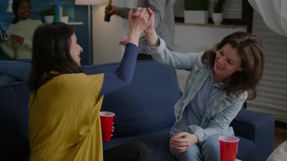 Cheerful Women Celebrating Friendship with High Five Late at Night