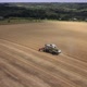 Flying around combine work in the wheat field. Beautiful landscape. Aerial drone footage - VideoHive Item for Sale