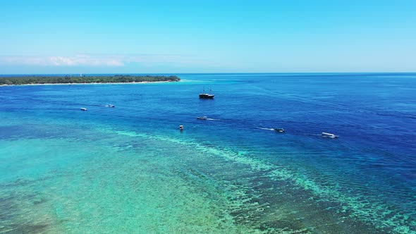 Vivid colors of panoramic view of boats sailing on deep blue sea and turquoise lagoon with coral ree