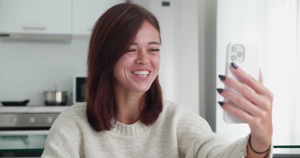 Beautiful Confident Positive Adult Woman in Sweater Sitting in Cozy Couch and Talking on Video Call