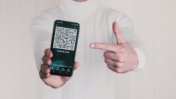 Male Hand Shows QR Code on Smartphone on White Background