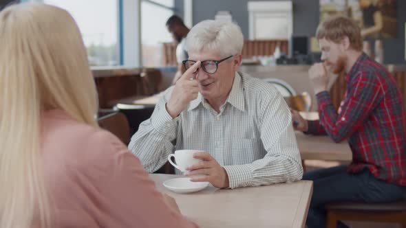 Senior Coupler Relaxing in Cafe Drinking Coffee and Communicating