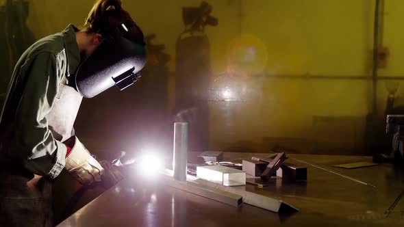 Female welder welding a metal