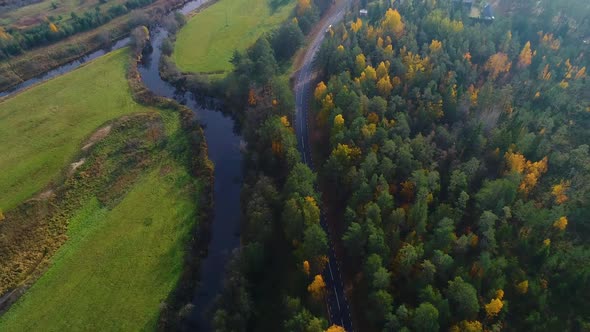 Aerial view of river crossing forest during Autumn, Estonia.