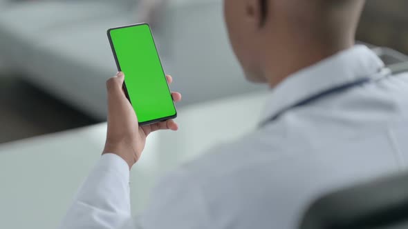 Rear View of African Doctor using Smartphone with Chroma Screen