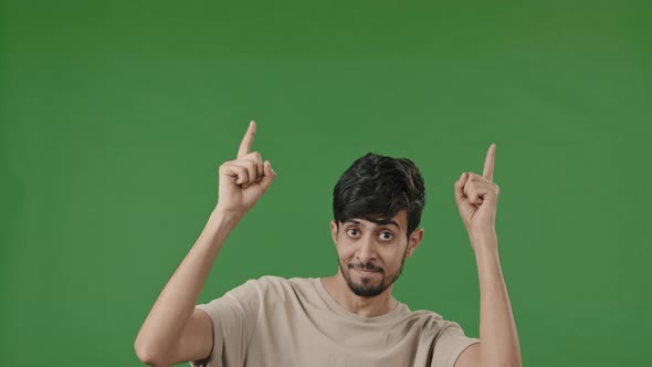 Positive Arab Man Points Forefingers Up at Copy Space for Advertisement Blank Place Recommends