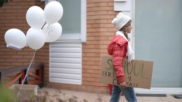 Side View Tracking Teenage Girl with School Strike for Climate Placard Walking in Slow Motion