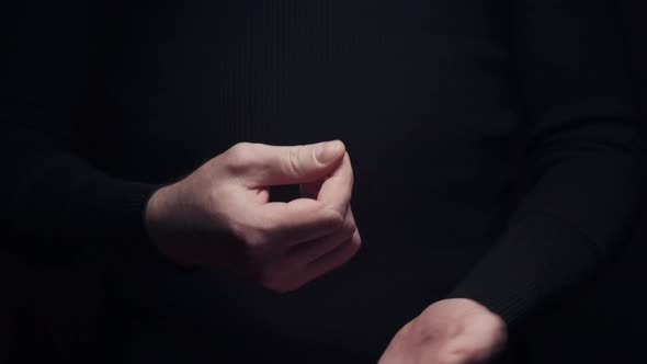 Male Hand Making Money Asking Sign Gesture Rubbing Fingers Together on Black Background