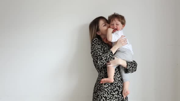 Mother with son on white wall background in home