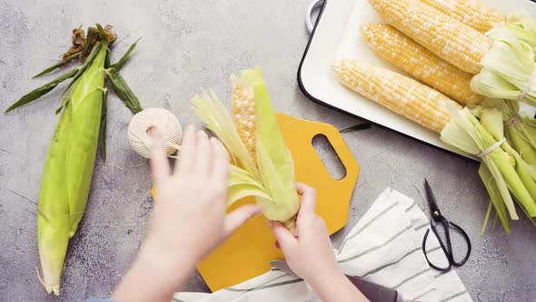 Step by step. Shucking organic corn to make Mexican corn on the cob Elote.